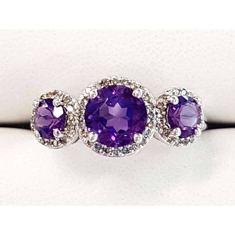 White gold ring featuring three round amethysts and diamonds