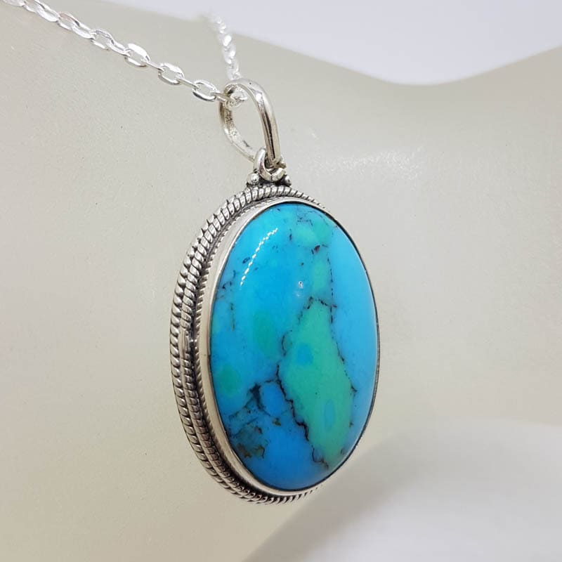 Sterling Silver Turquoise Oval with Patterned Rim around Bezel Set Pendant on Silver Chain