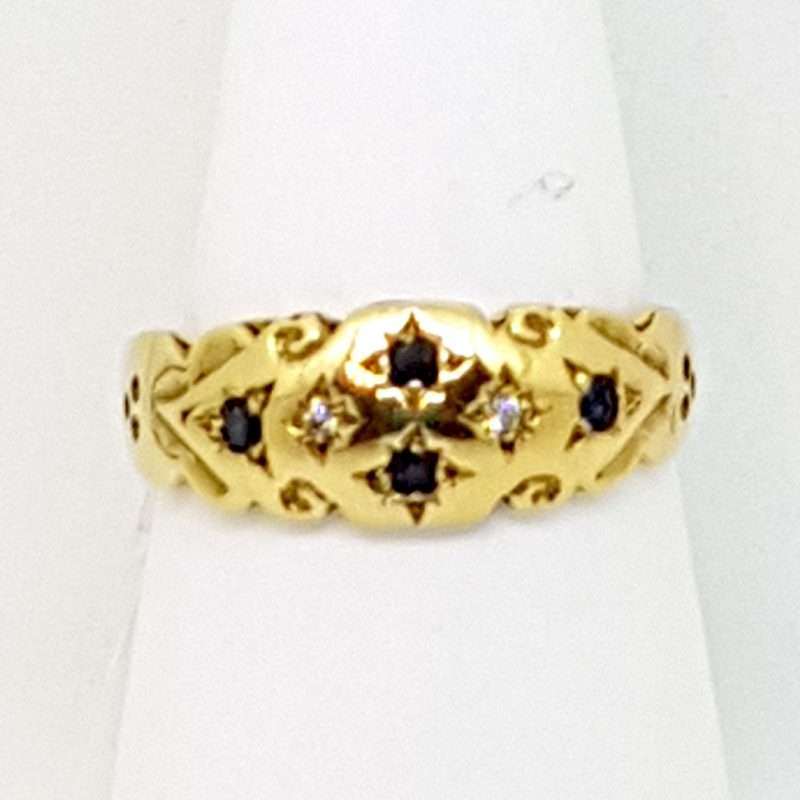 Four small black sapphires inset on 9ct gold ring in cross pattern