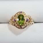9ct gold ring featuring large oval faceted peridot surrounded by seedpearls and 4 delicate amethyst gemstones