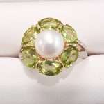 9ct gold ring featuring large central pearl surrounded by 6 peridot gems and diamond encrusted gold band