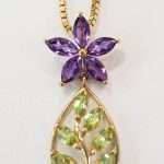9ct gold necklace featuring 6 leaf-shaped peridot gems below an amethyst petal flower