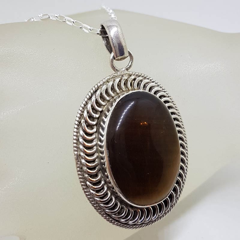 Sterling Silver Tiger Eye Large Oval Bezel Set Ornate Patterned Rim Pendant on Silver Chain Sterling Silver Tiger Eye Large Oval Bezel Set Ornate Patterned Rim Pendant on Silver Chain