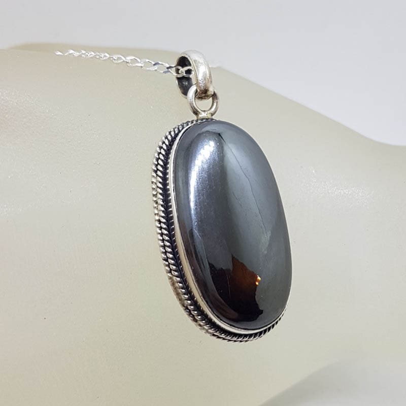 Sterling Silver Iron Ore / Hematite Bezel Set Oval with Twist Design on Rim Pendant on Silver Chain Sterling Silver Iron Ore / Hematite Bezel Set Oval with Twist Design on Rim Pendant on Silver Chain